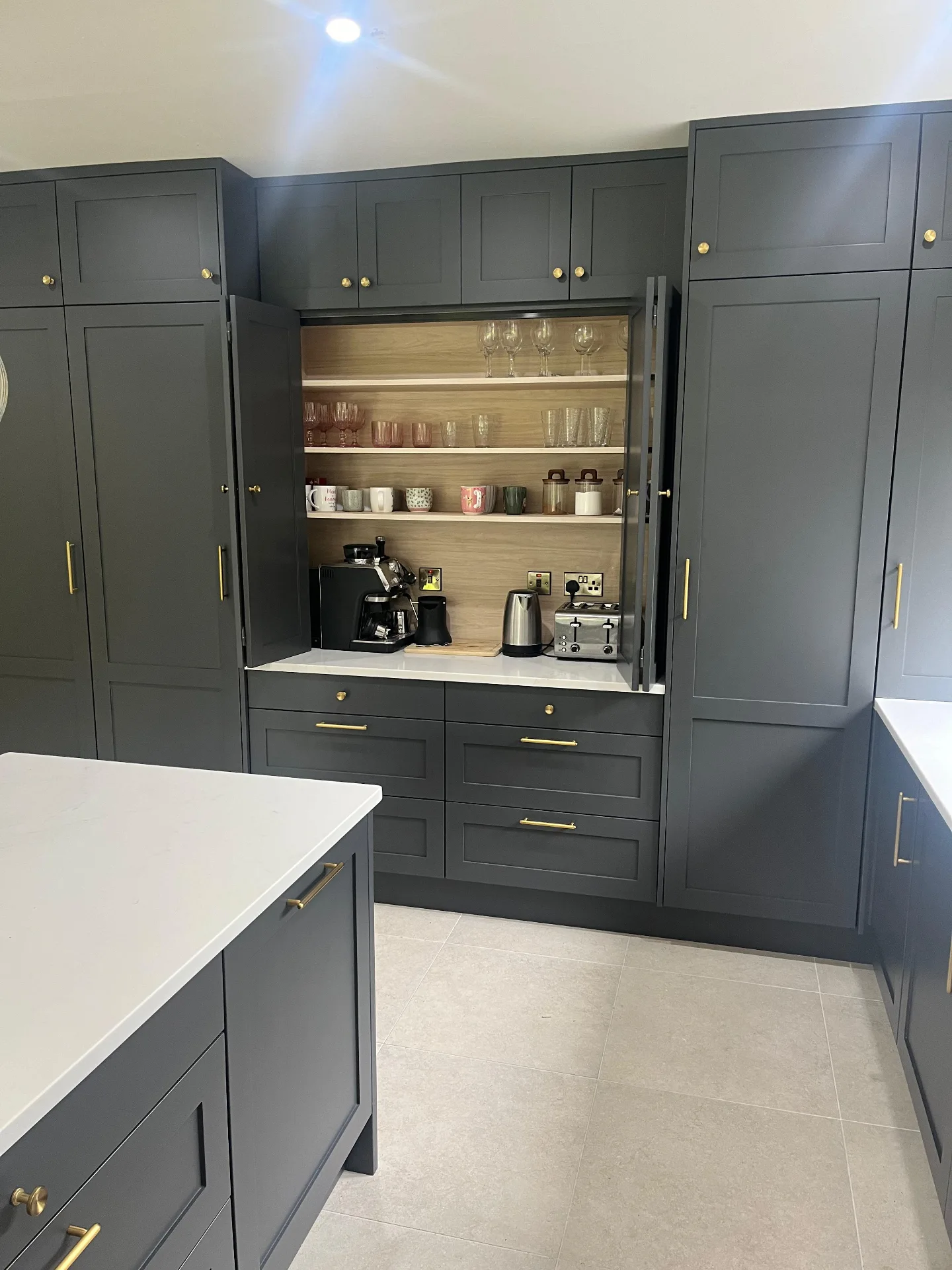 Open butler's pantry in a charcoal kitchen showing interior shelving and storage.