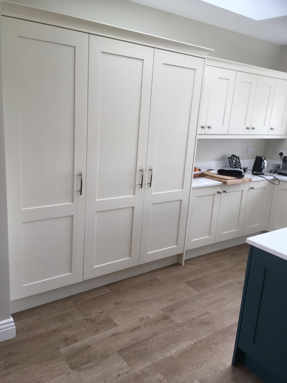 White floor-to-ceiling fitted kitchen storage cabinets.