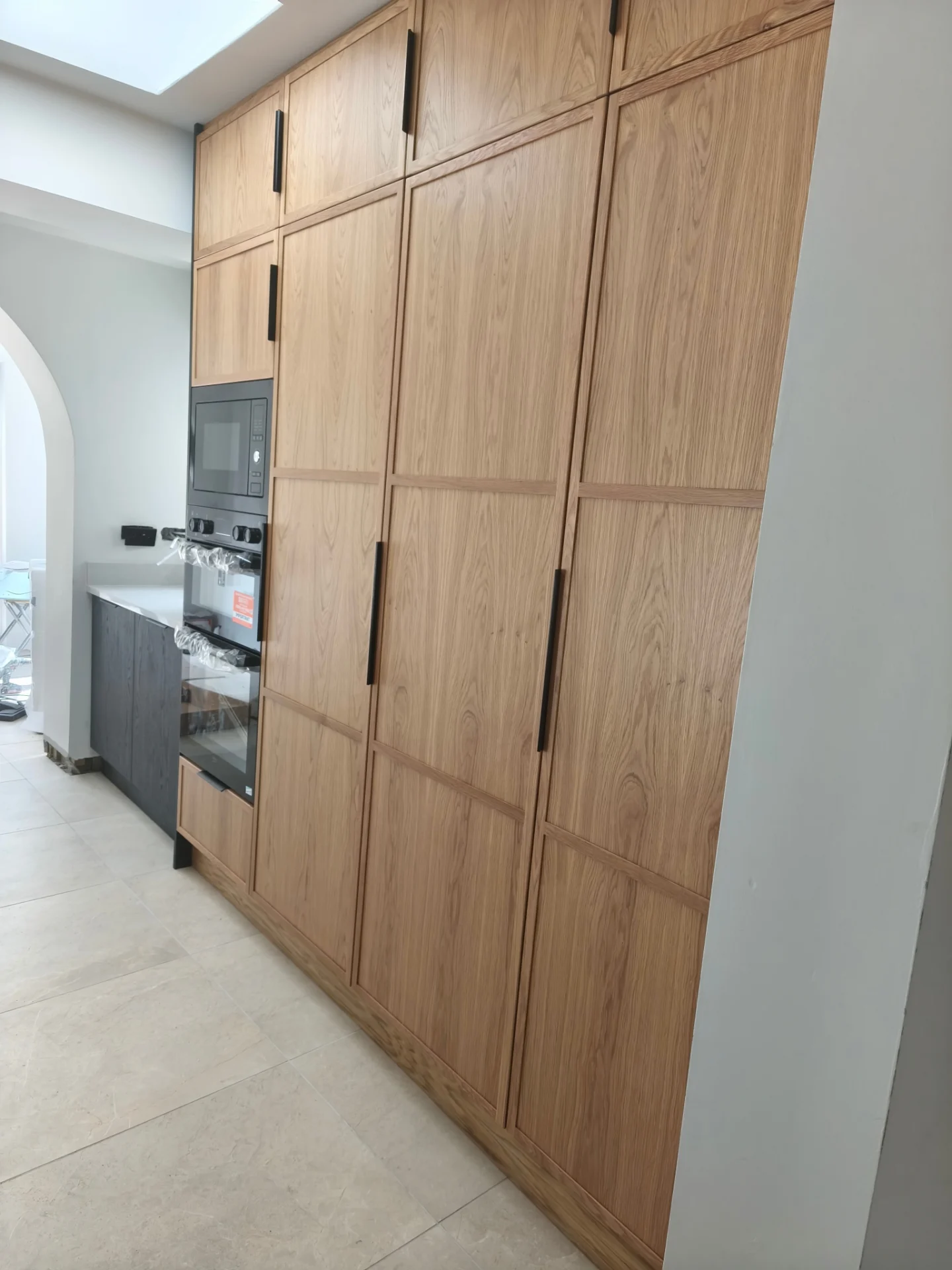 Wood galley kitchen with arched doorway and made-to-measure cabinetry.